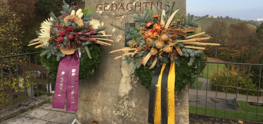 Mahnmal auf dem Friedhof mit Kranzschmuck