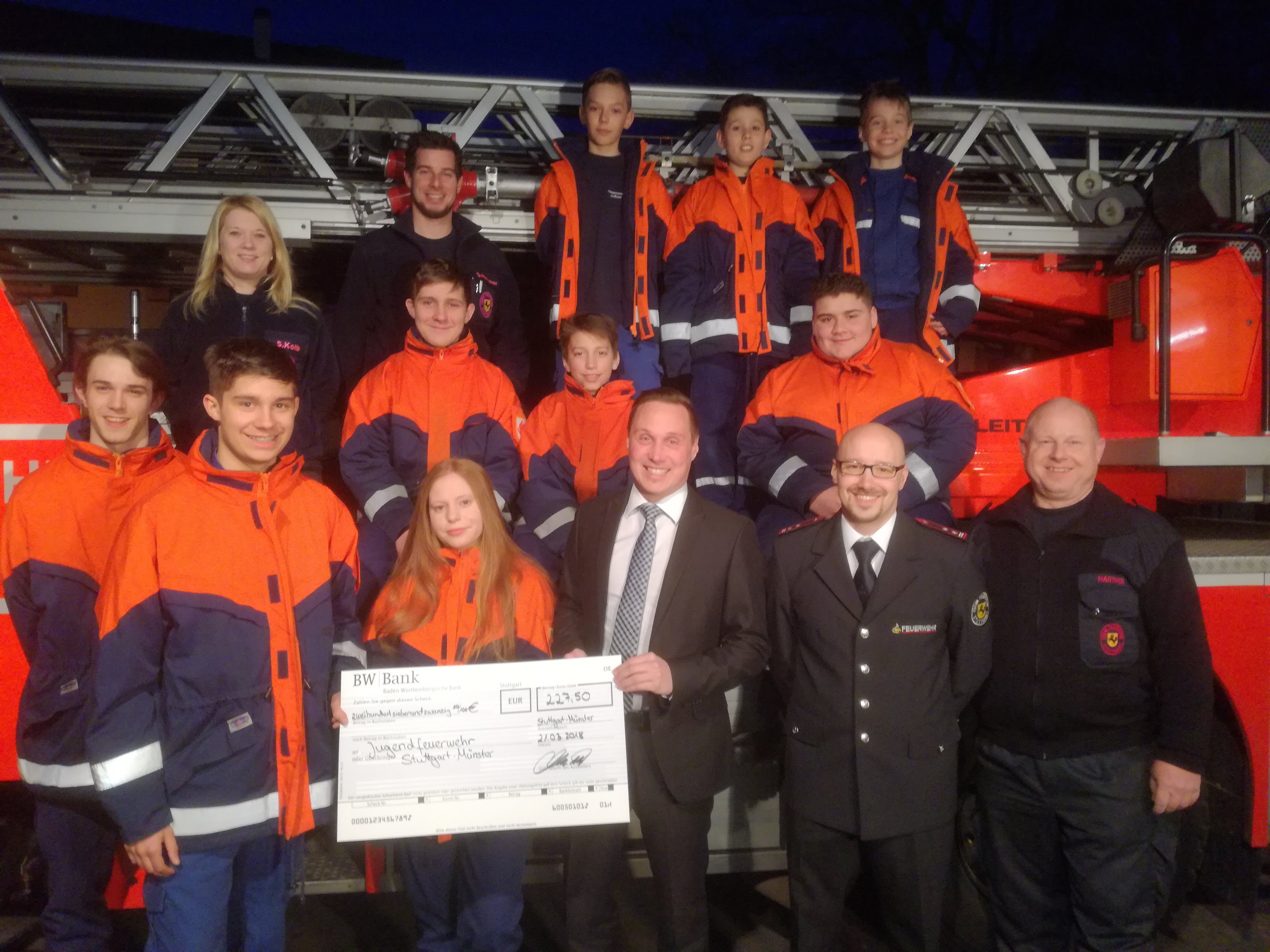 Übergabe der Spende: Beteiligte vor Drehleiter