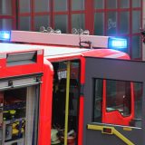 Feuerwehrfahrzeug mit offener Tür und blinkendem Blaulicht