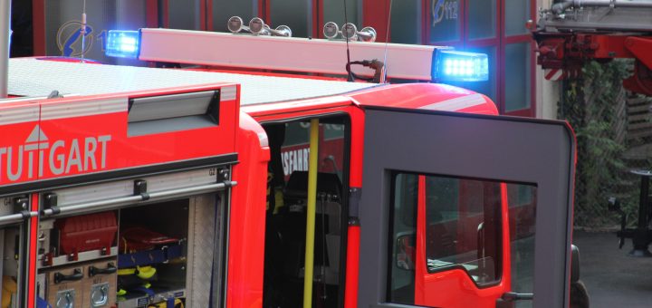 Feuerwehrfahrzeug mit offener Tür und blinkendem Blaulicht